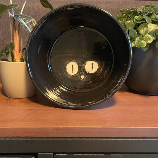 Zwarte kom met kattengezicht